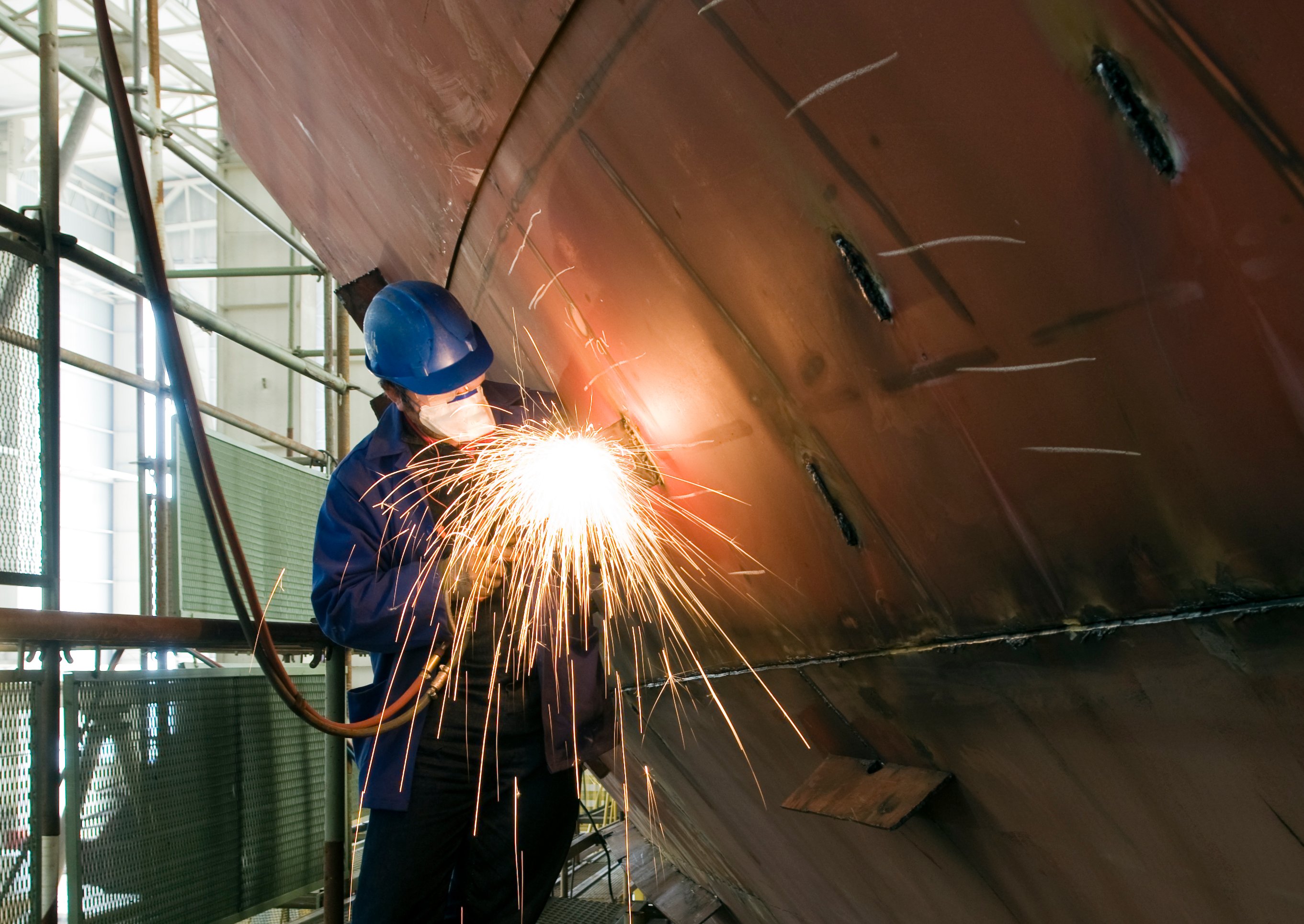 Welder working on a ship hull