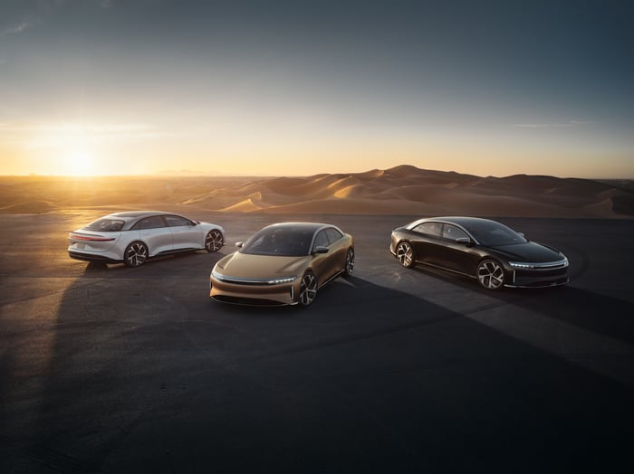 Various trims of the Lucid Air luxury sedan in the desert at sunrise. 