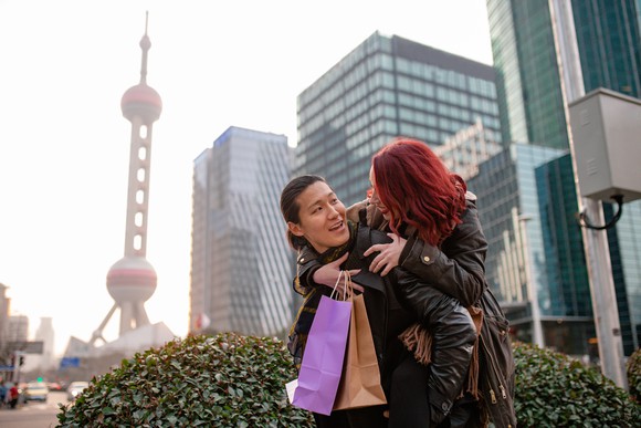 Portrait of a couple shopping by the Oriental Pearl Tower in Shanghai. 