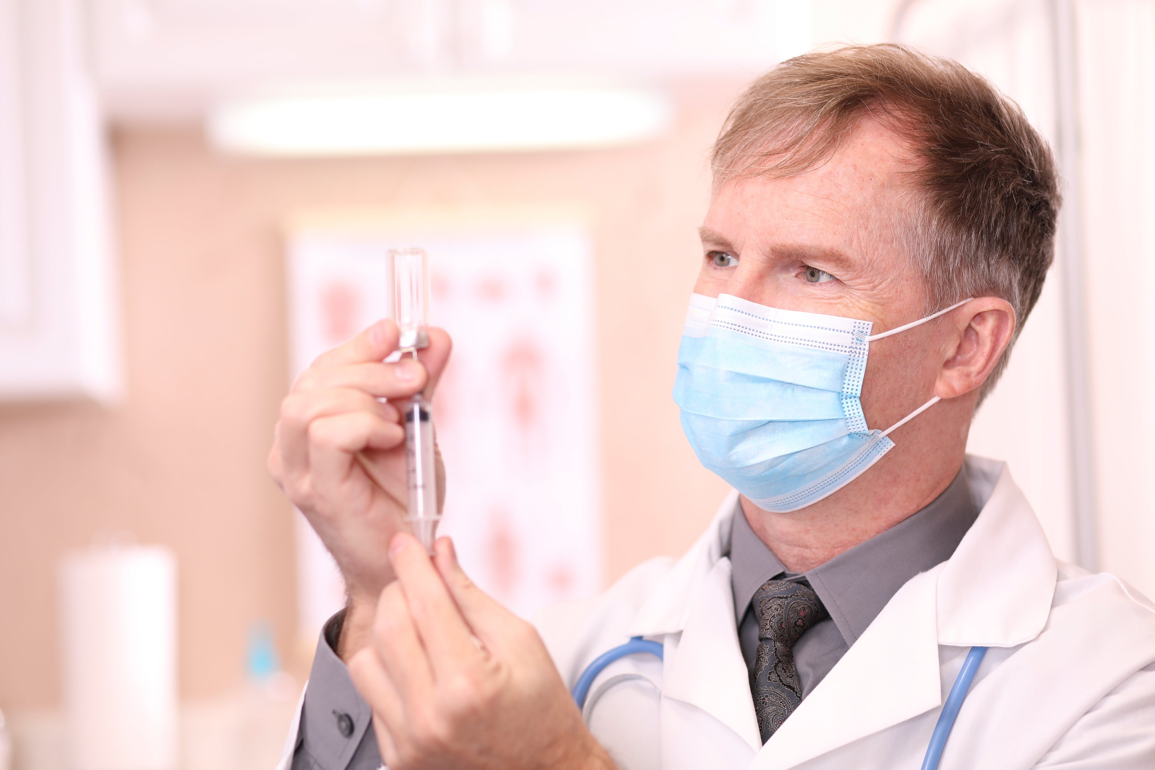 Doctor preparing syringe for coronavirus vaccine. 