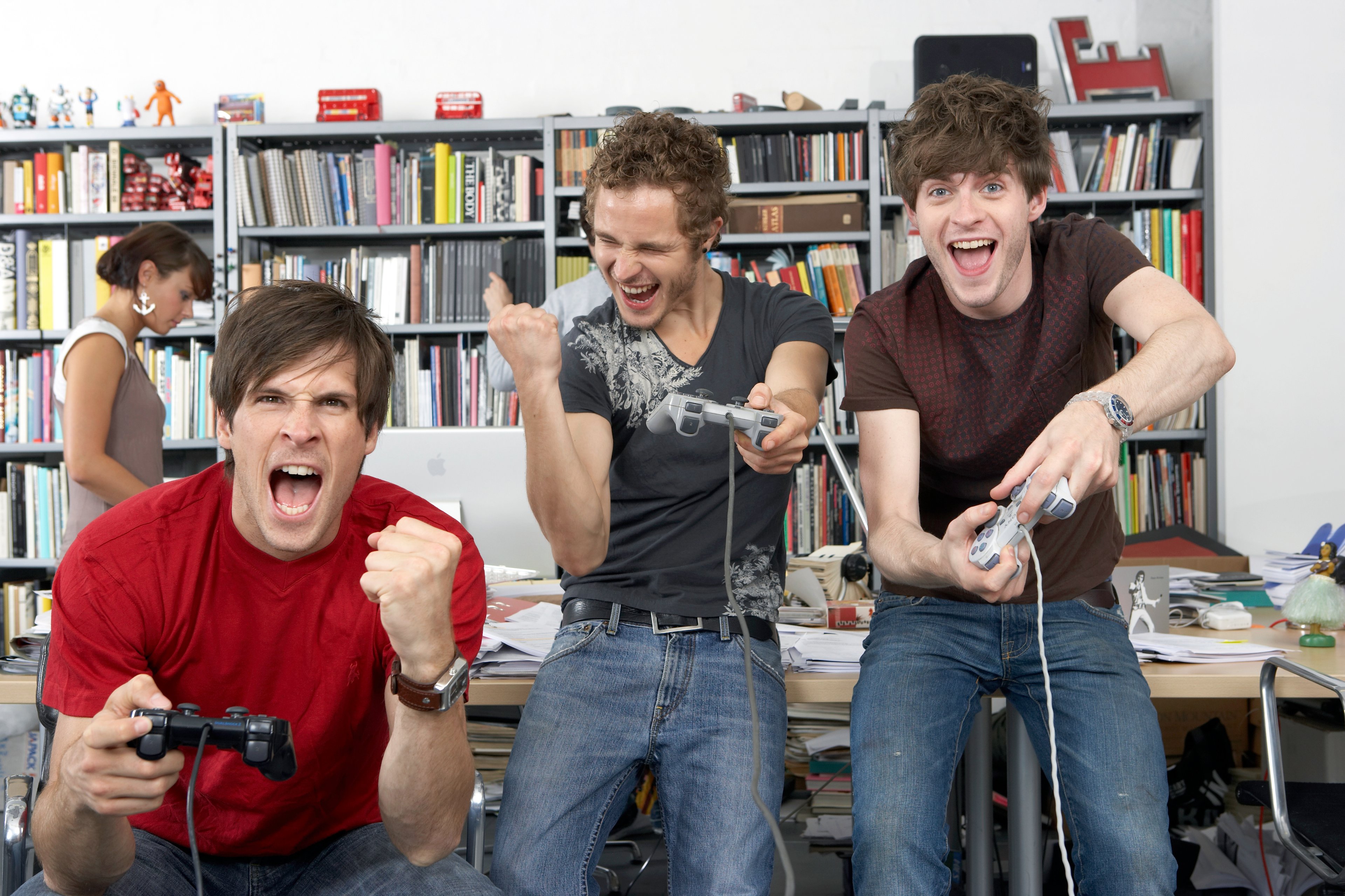 Colleagues celebrating their victory on a video game console. 