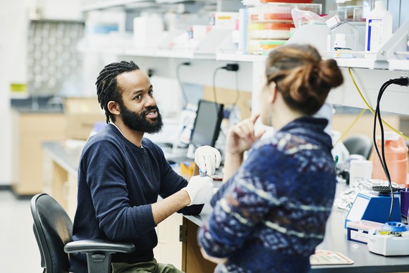 Two coworkers in a biotech laboratory.