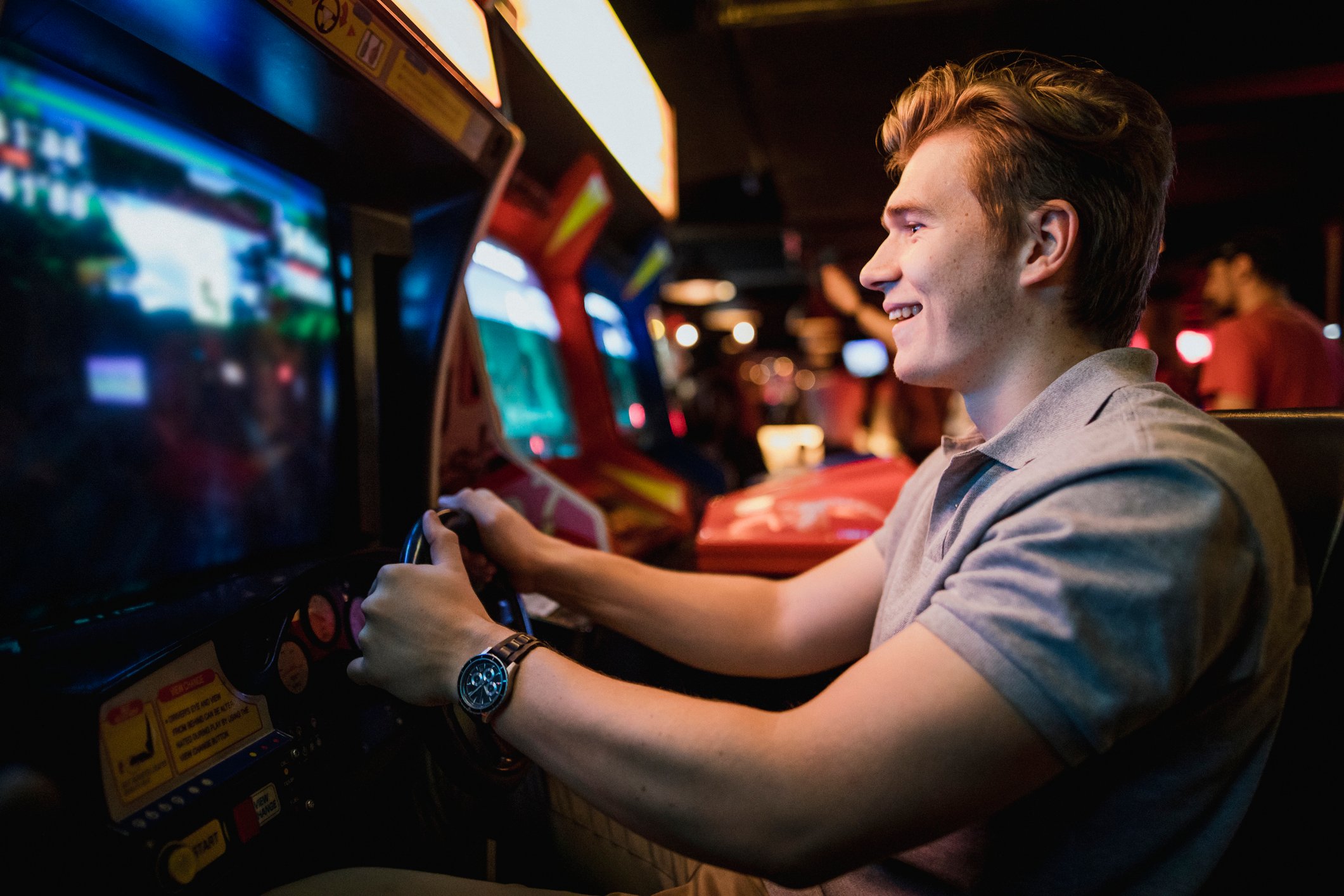 A young man playing an arcade game.