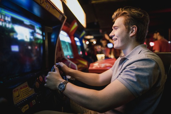 A young man playing an arcade game.