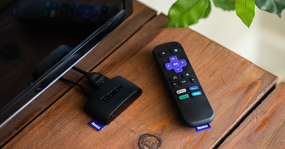 A Roku remote and device on a table.