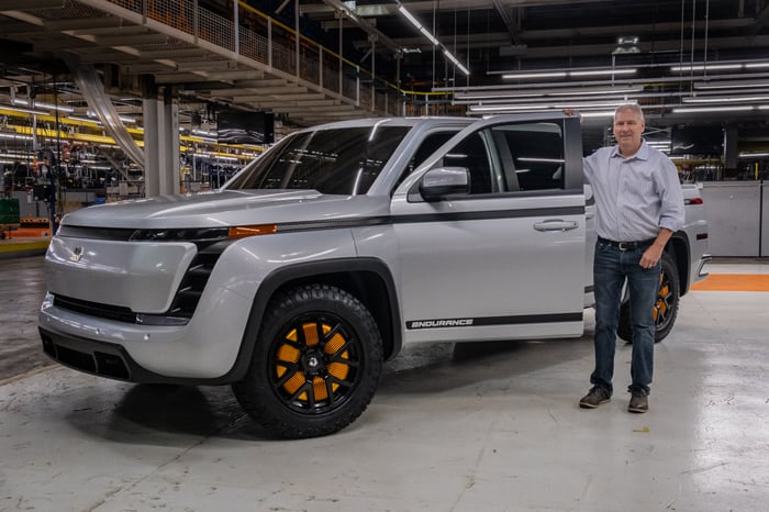 Burns is shown with a silver prototype Lordstown Endurance, an electric pickup truck.