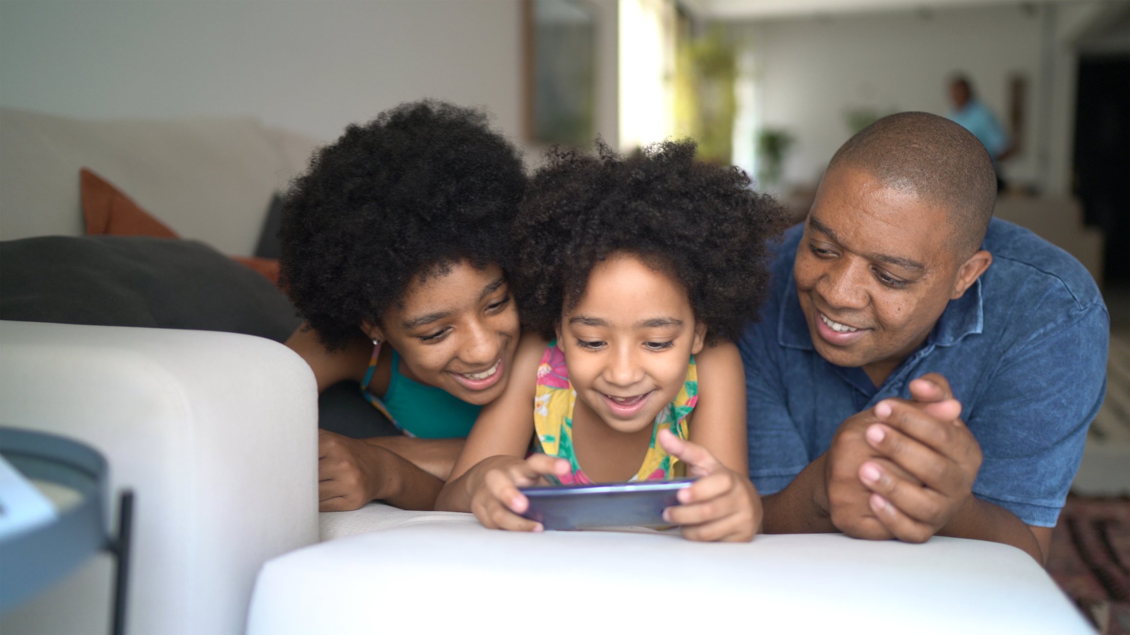family of 3 watching something on smartphone