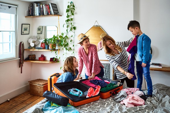 A family unpacking their luggage in a room.