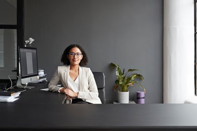 Smiling person at desk_GettyImages-1210916959