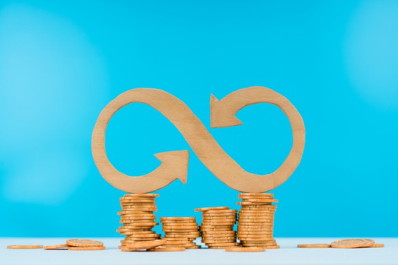 Wooden infinity sign on top of wooden coins.