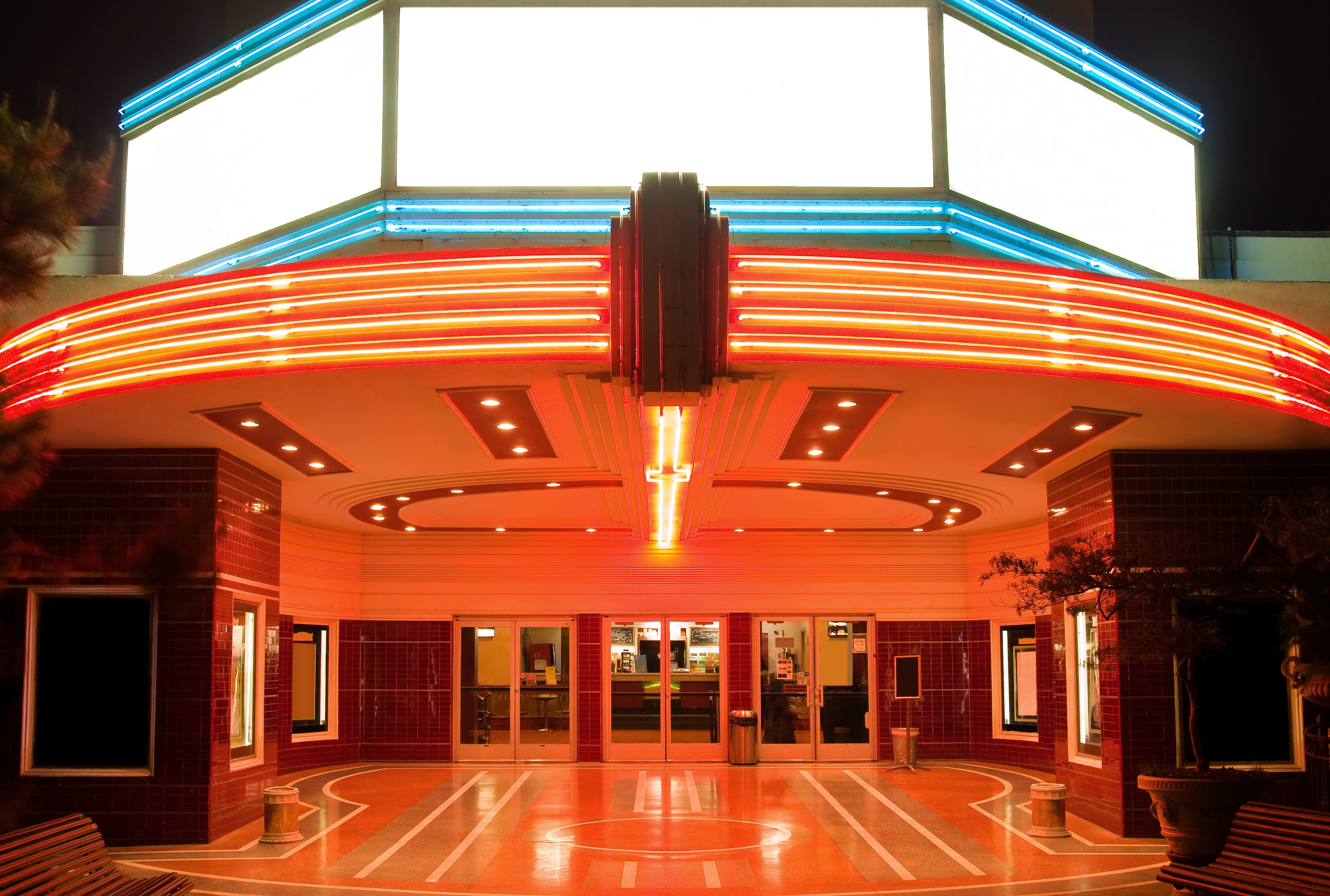 Neon lit exterior of a movie theater.