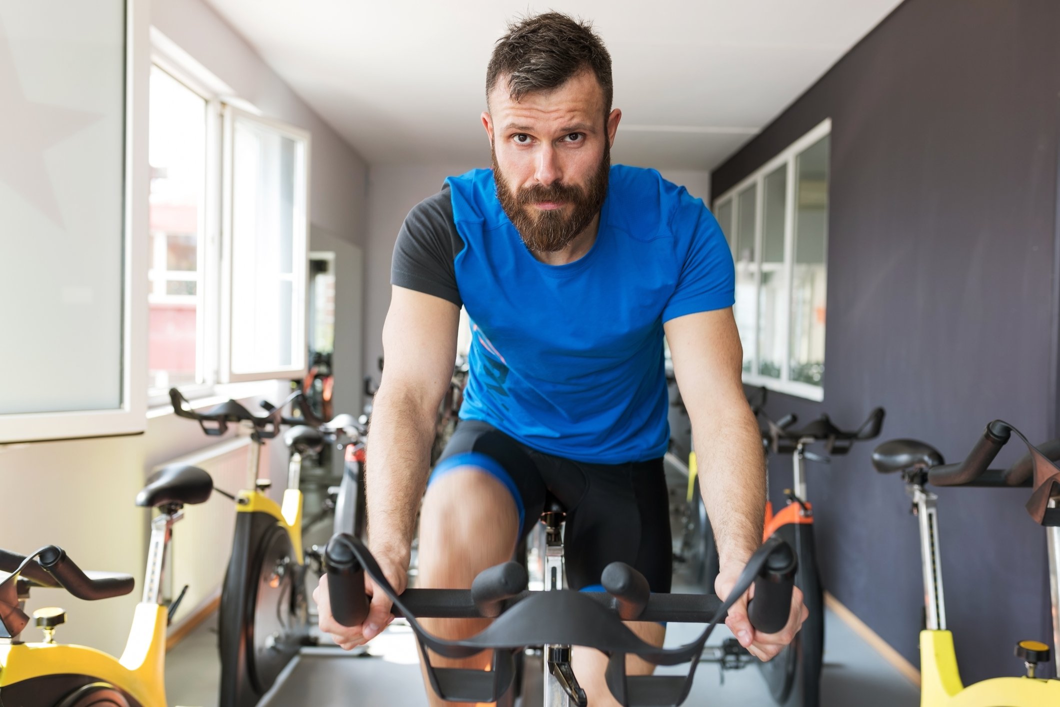 A man in workout clothes riding a stationary bike.