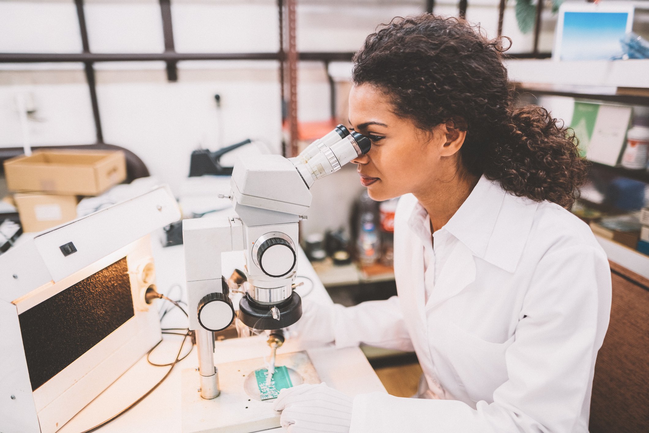 A technician examines a chip under a microscope.