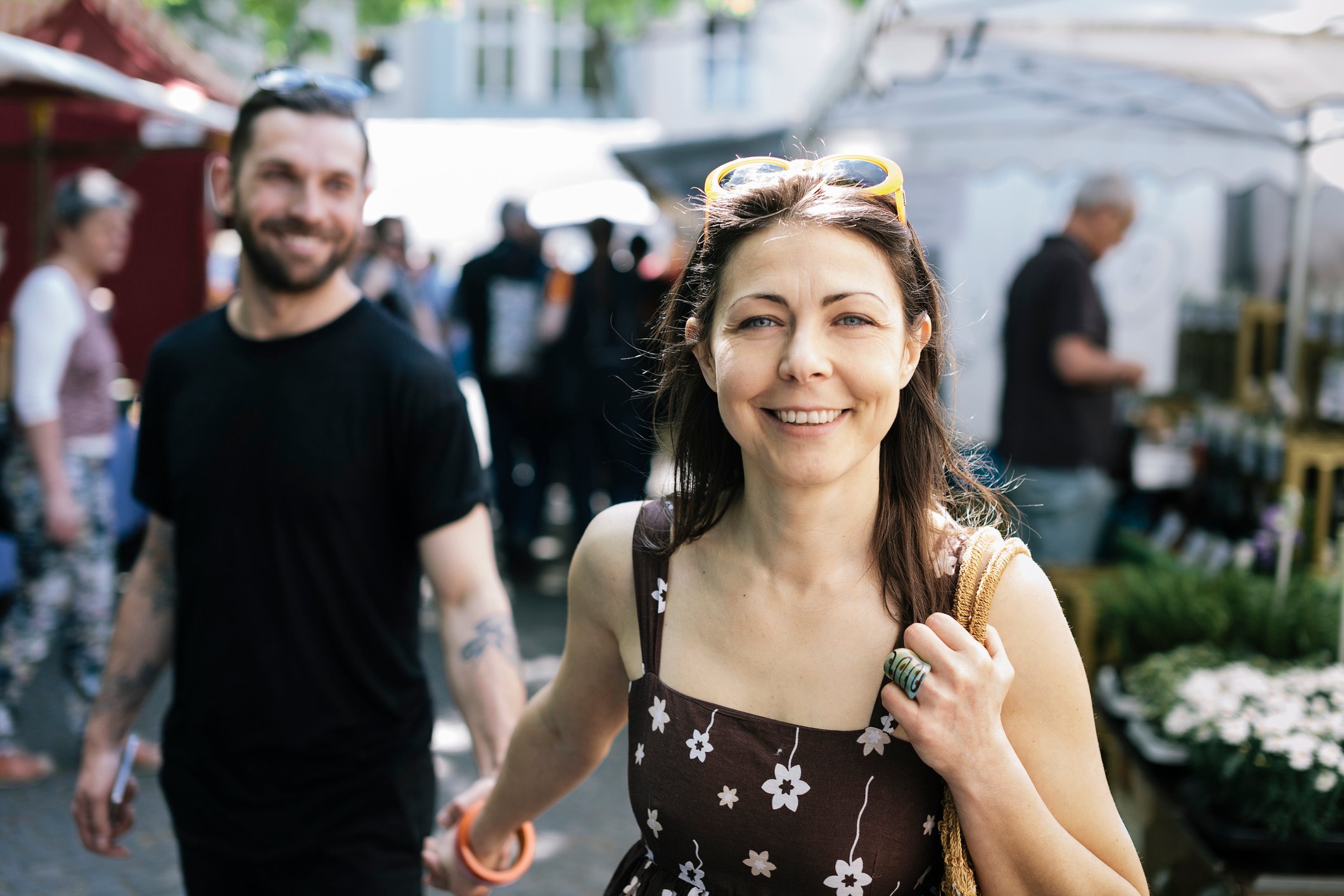 Woman smiling in outdoor market because she knows she's saving for retirement.