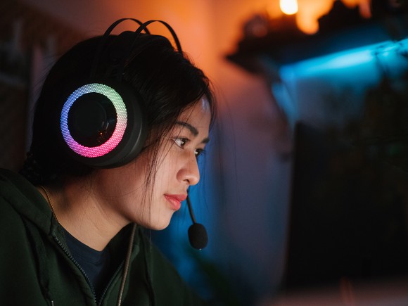 A gamer wearing a headset with a microphone while playing a game on a PC.