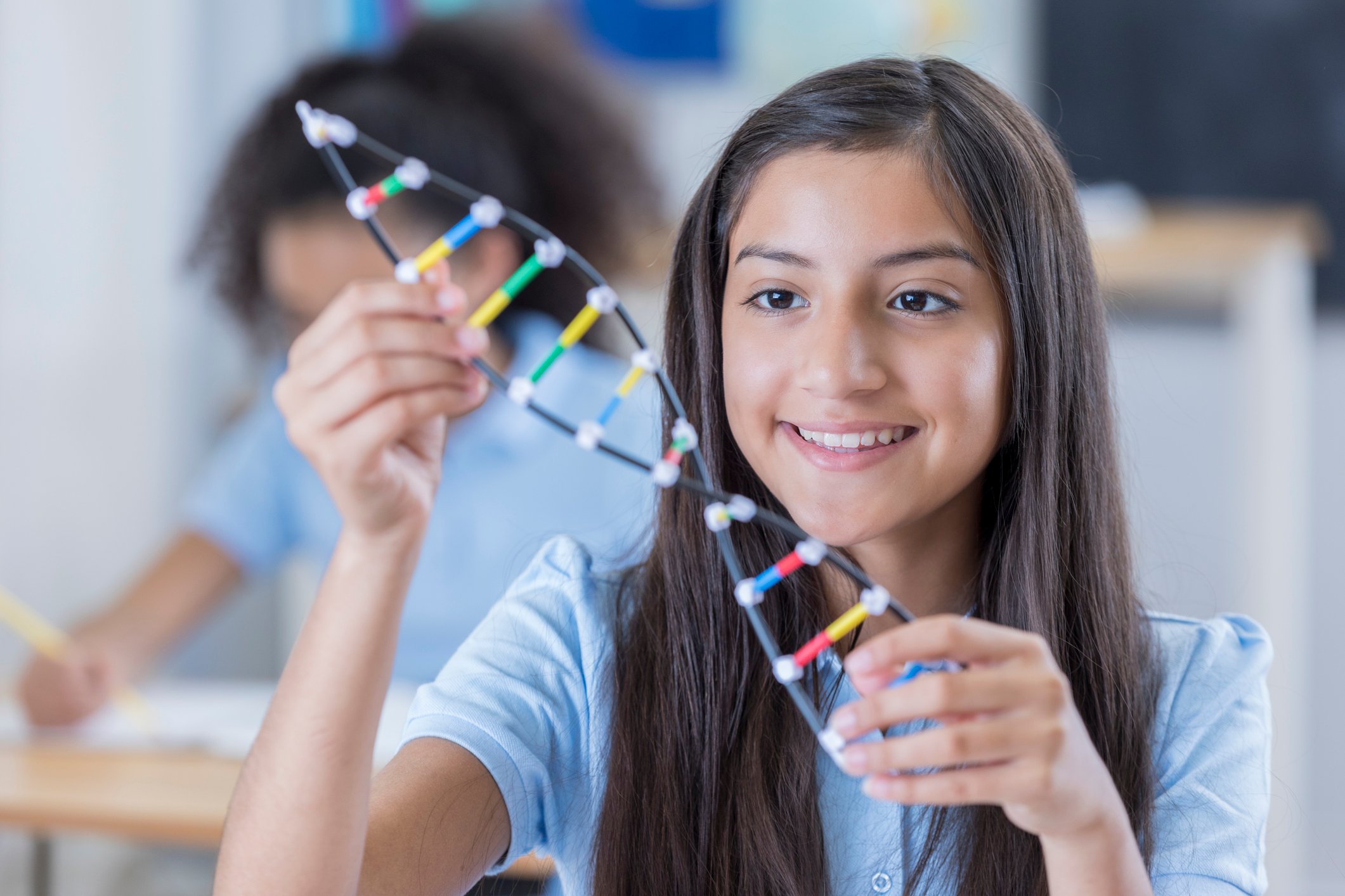 Young girl holding a model DNA strand