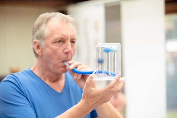 A patient testing their lung capacity at a doctor's office.