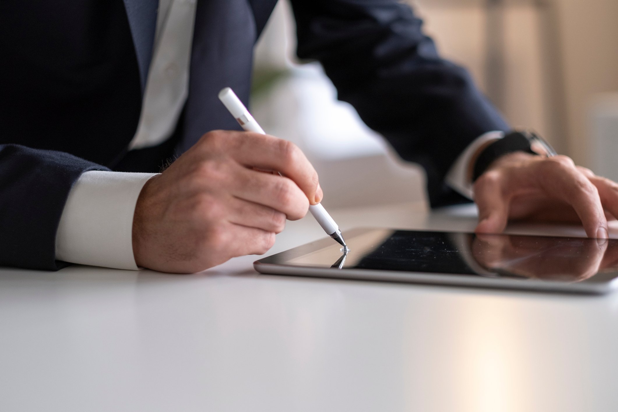 A man signing a tablet.