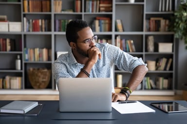 Man thinking in front of laptop