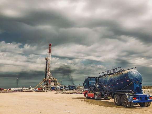 Shale rig with tanker in foreground.