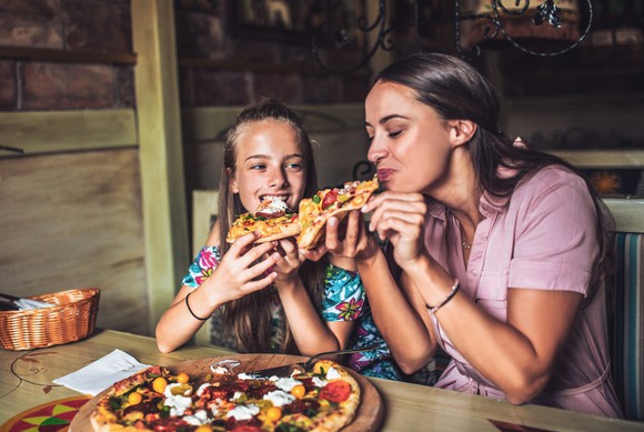 Lady and girl enjoying pizza 