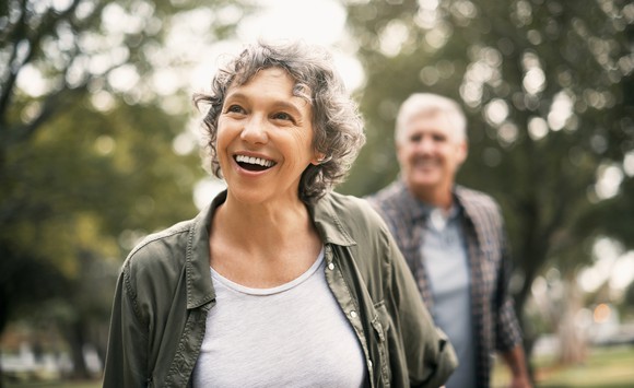A happy senior couple walking in a park.