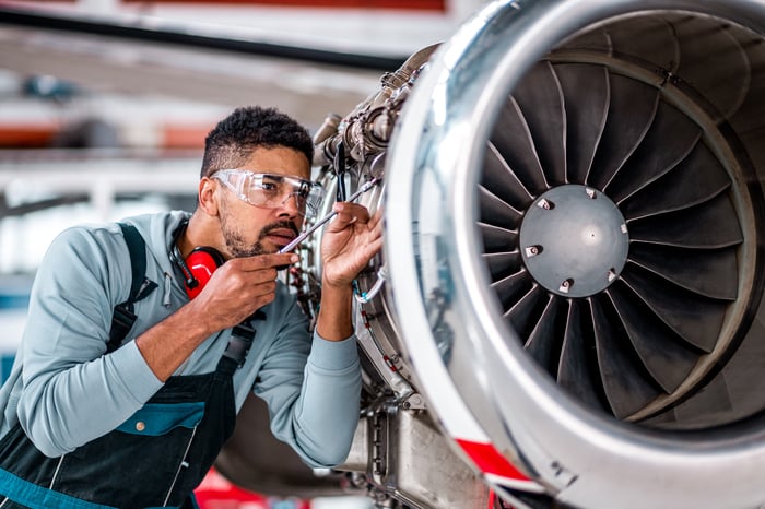 Worker working on an aircraft jet engine.