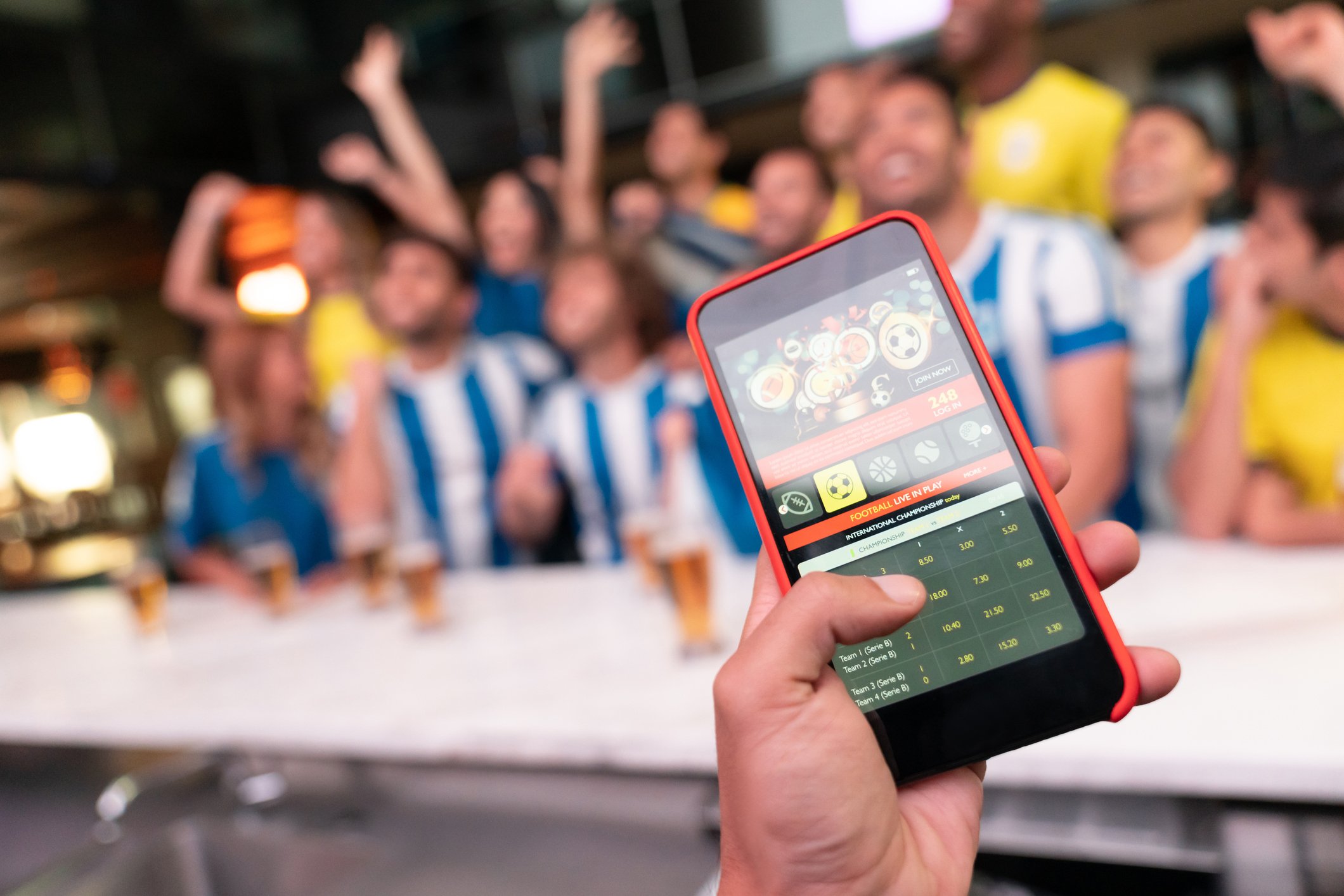 Betting on a game on a mobile device in a bar. 