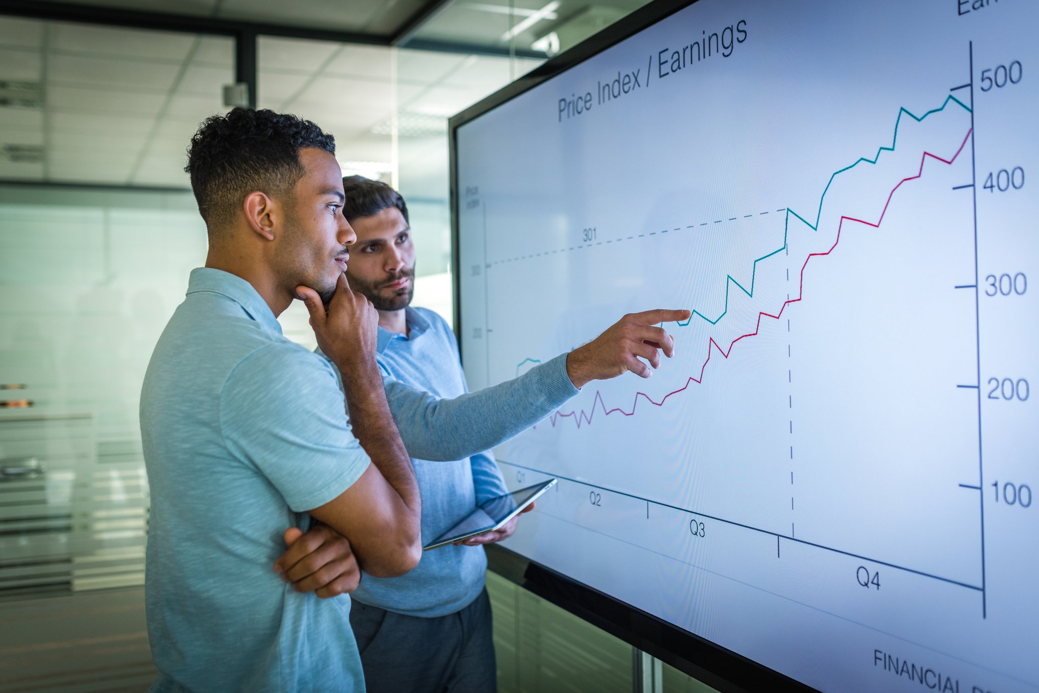 Two people looking at a financial chart.