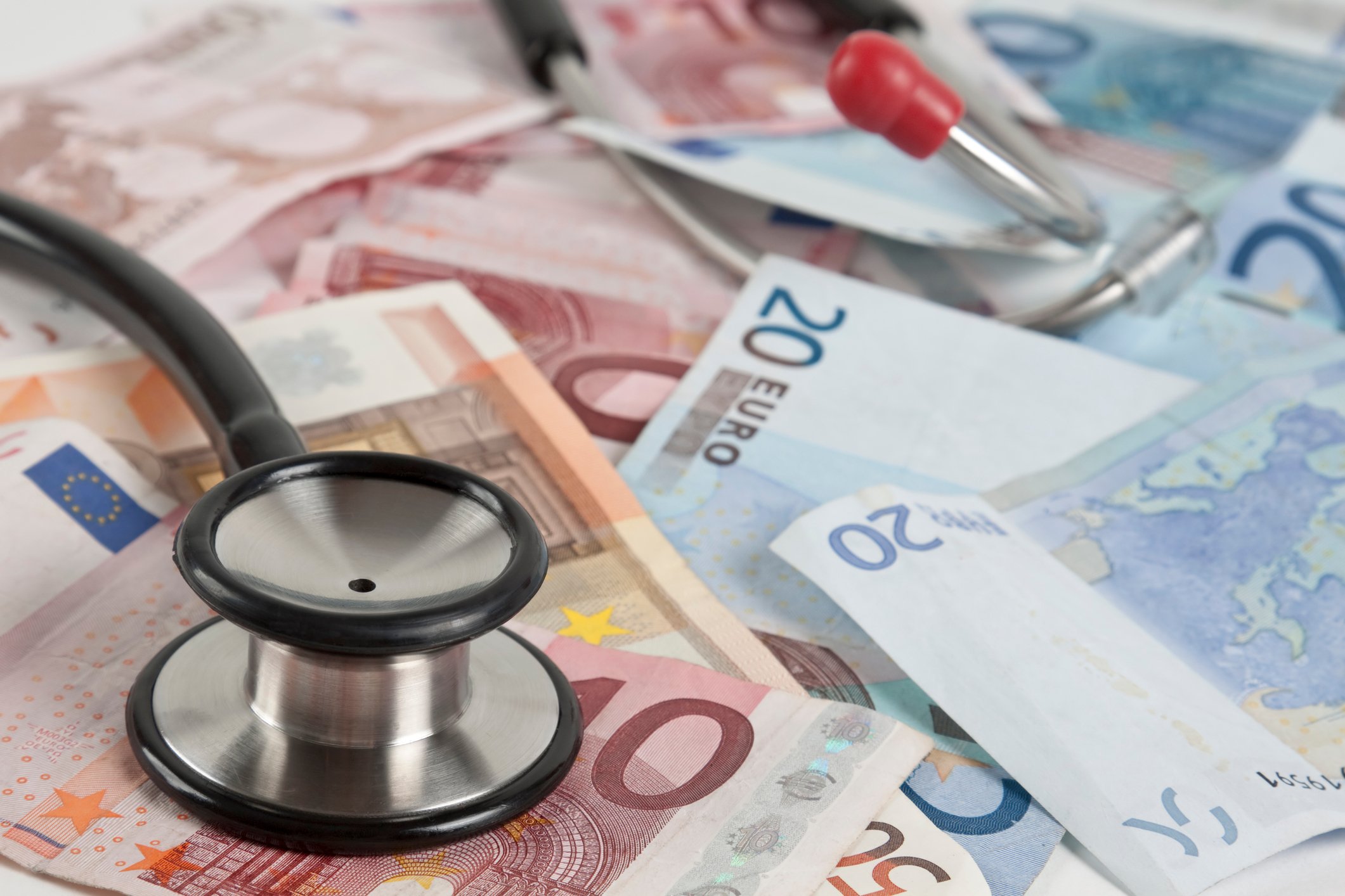 Stethoscope atop a collection of euro notes.