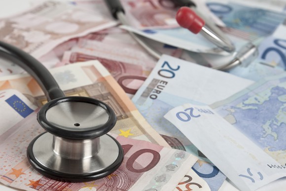 Stethoscope atop a collection of euro notes.