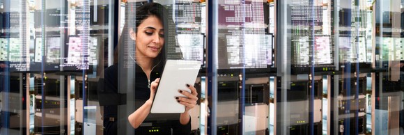 IT professional looking at a document in a data center.