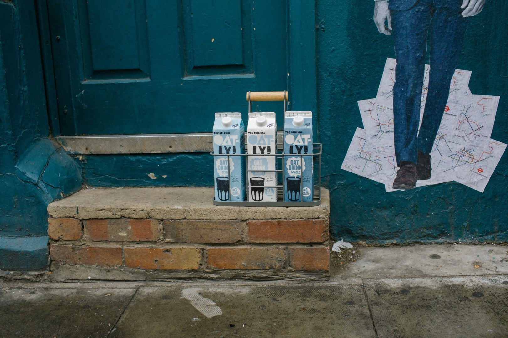 Oatly cartons sitting on a doorstep. 