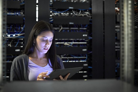 A woman on a tablet in a server room