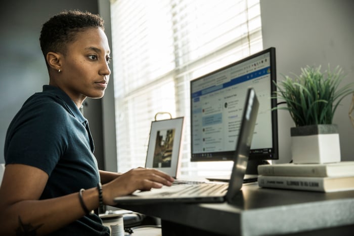 Young person sitting at a desk looking at a computer