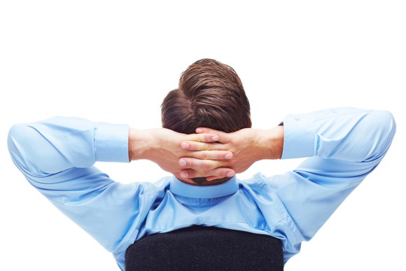 Person leaning back in a chair, relaxed, with hands behind their head.