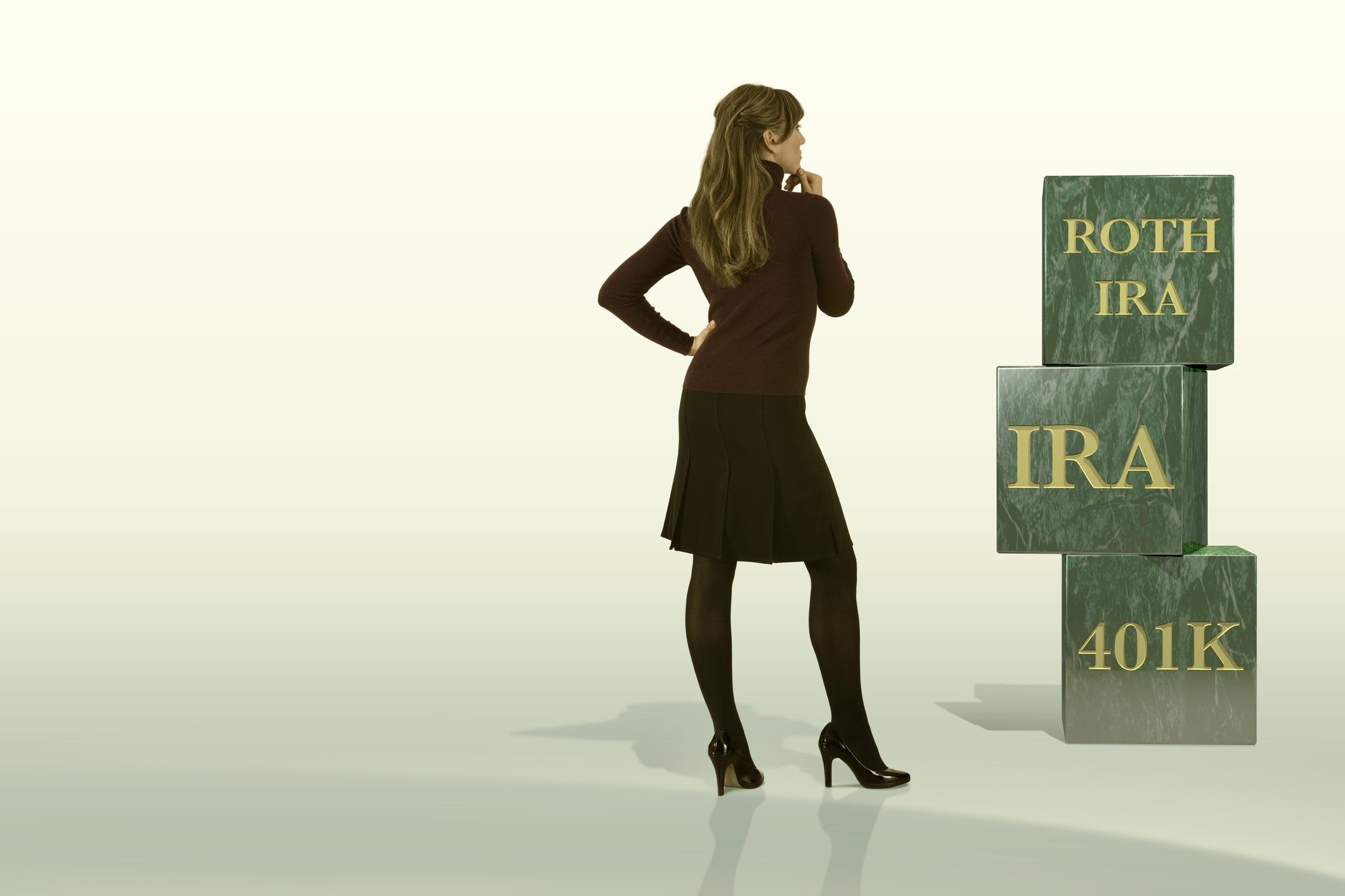 Person staring at blocks reading Roth IRA, IRA, and 401k.