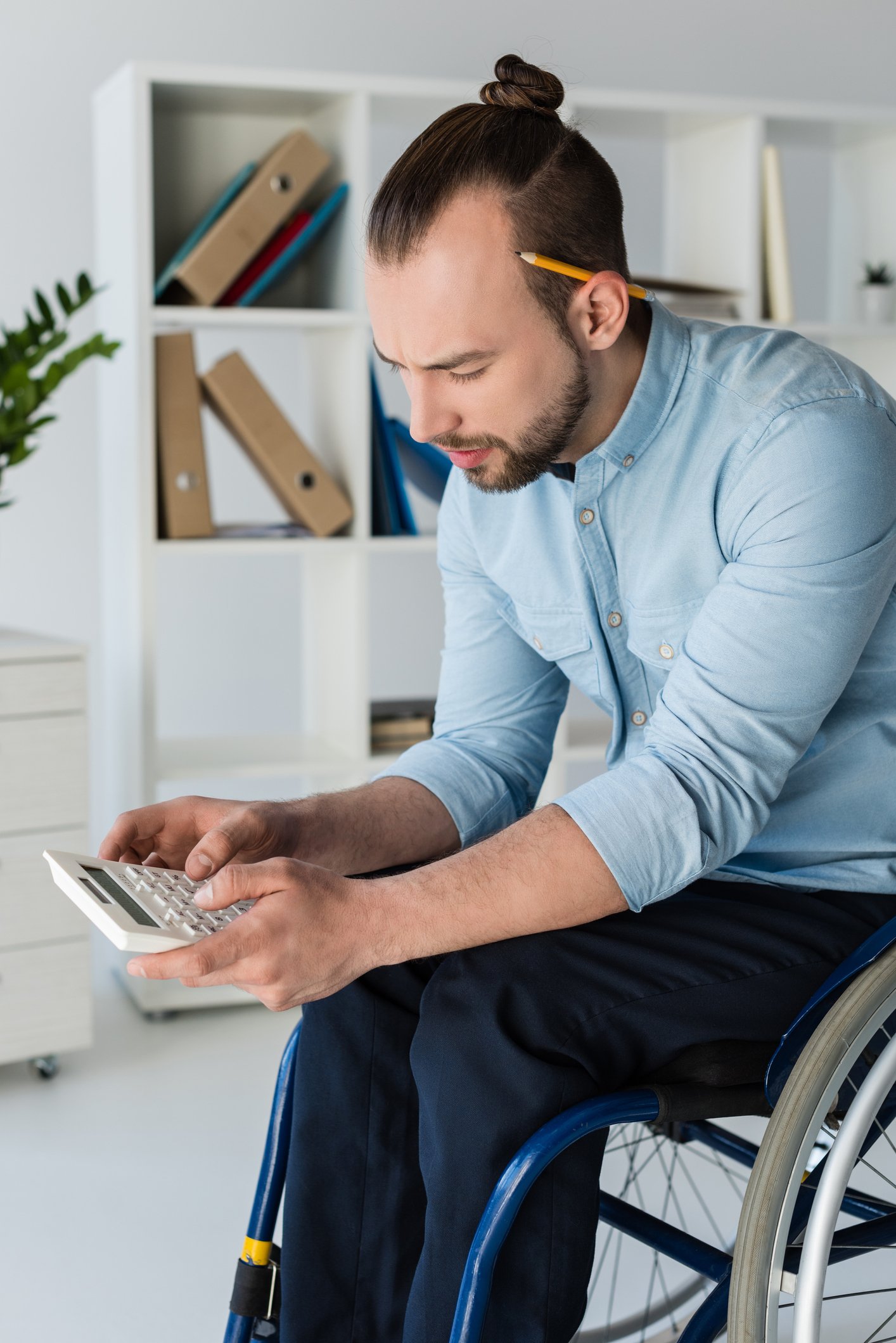 Person in wheelchair using a calculator.