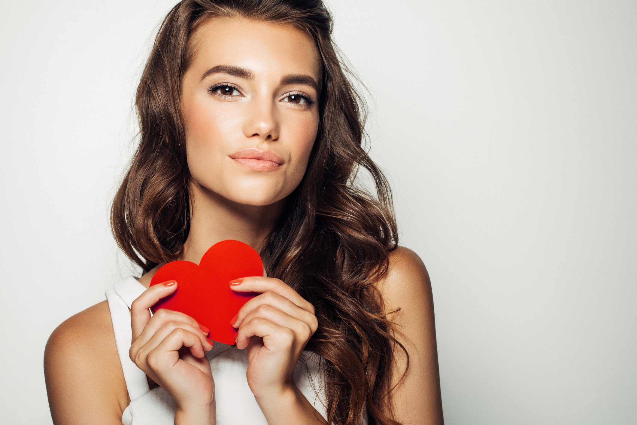Woman holding a red paper heart.
