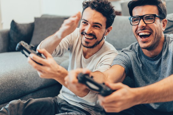 Two people sitting on a couch playing video games.