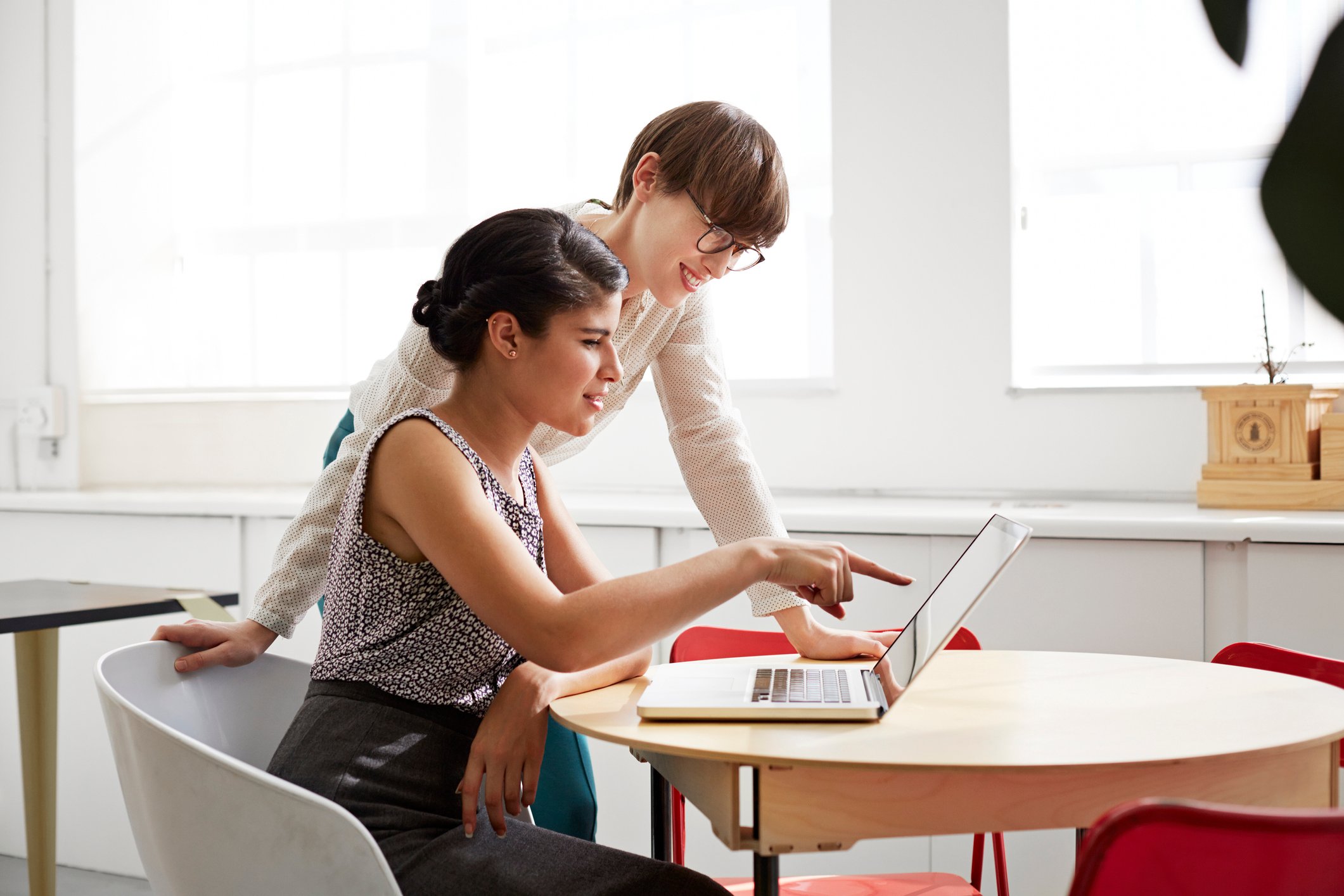 Two people looking at a laptop screen.