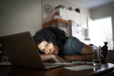 Woman with concerned expression looking at laptop