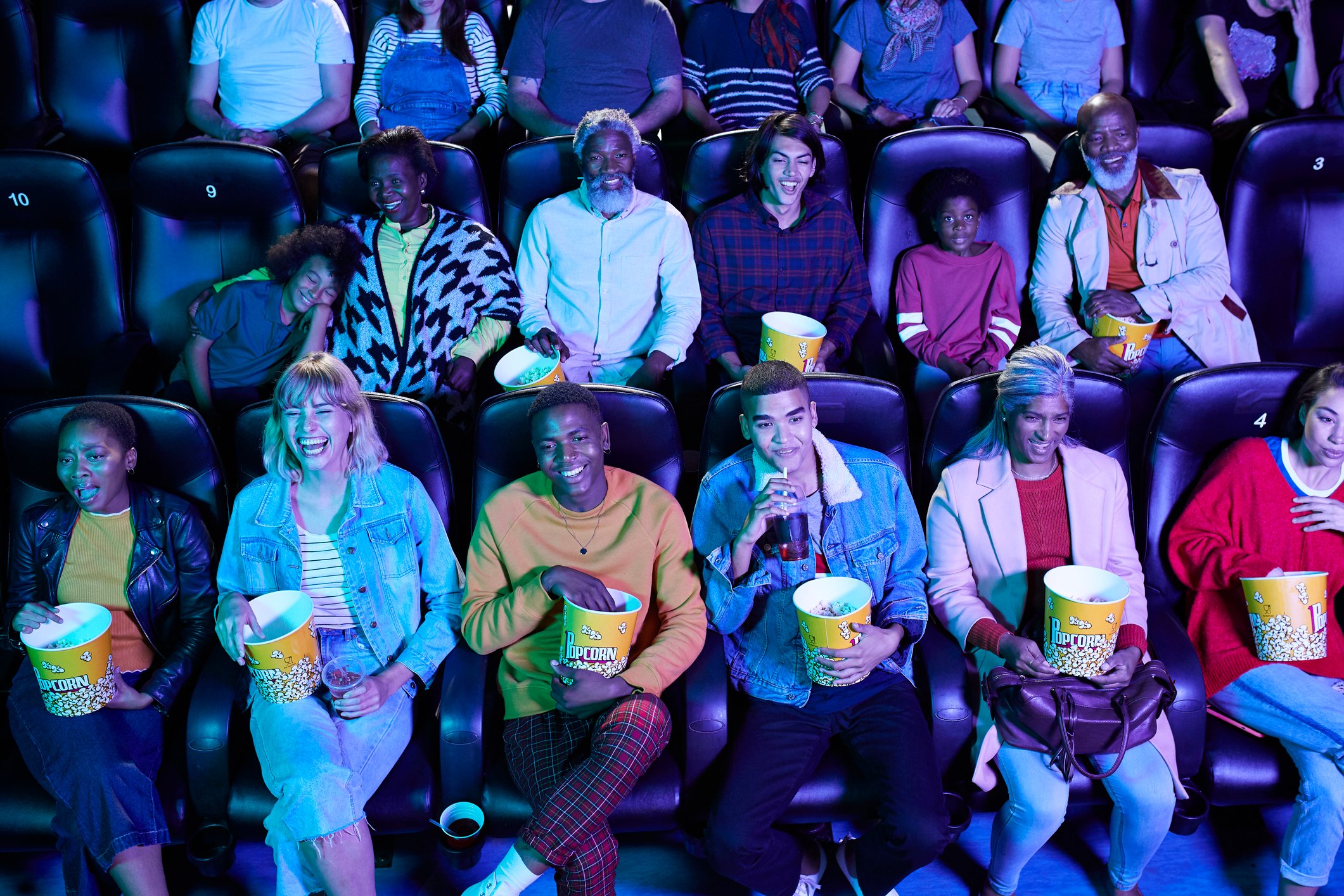 Smiling people sitting in a movie theater.