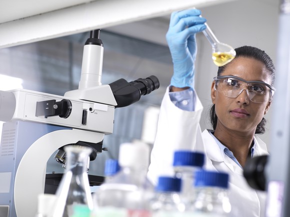 Lab researcher mixes chemicals in a test tube.