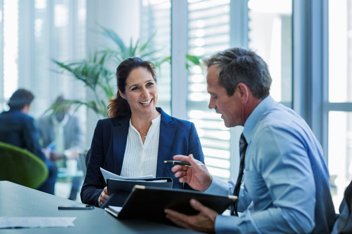 Two colleagues having a conversation in an office.