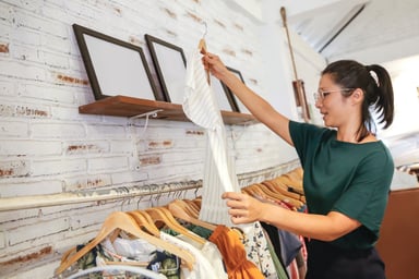 young woman looking at a top in a store