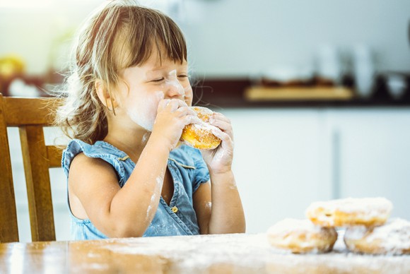 Child eating donut somewhat messily.