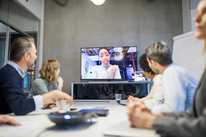 Businesspeople in meeting with virtual participant.