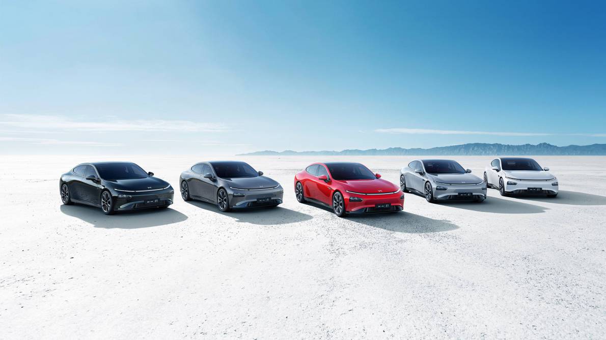 A lineup of five XPeng vehicles in a barren desert.
