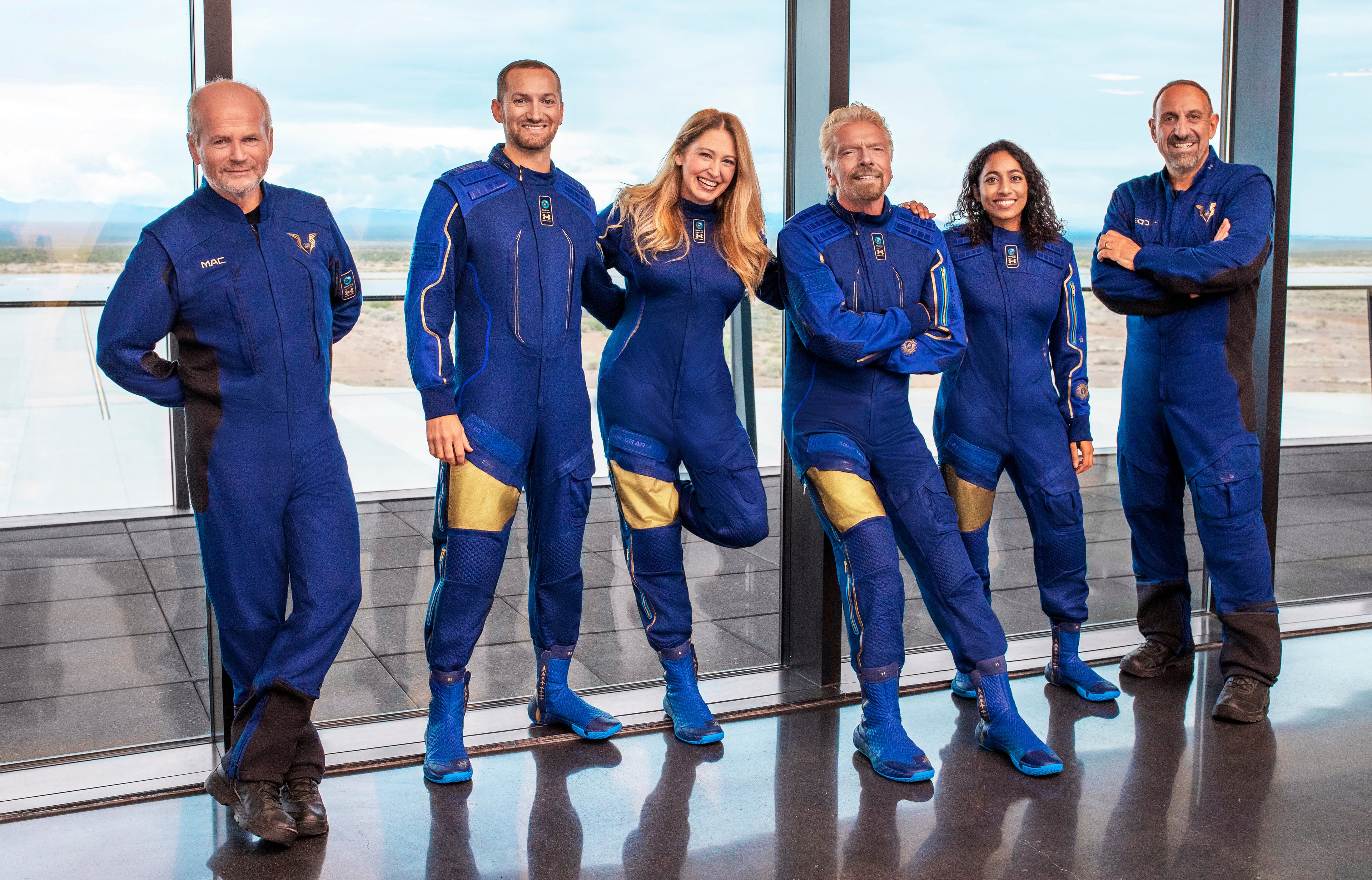 The crew of Unity, including Virgin Galactic founder Richard Branson, poses in their flight suits.